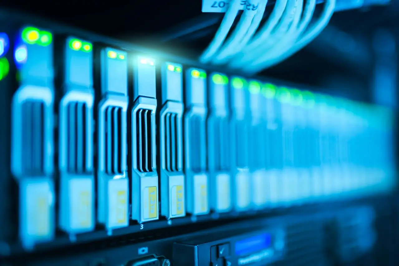 Accueil Detailed image of a server rack with glowing lights in a modern data center.
