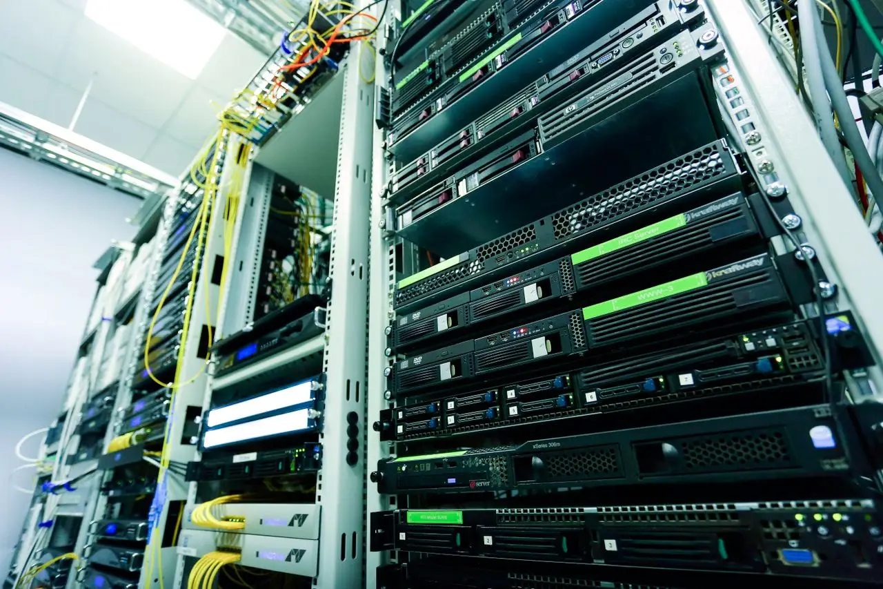 Nos Services High-tech server rack in a secure data center with network cables and hardware components.