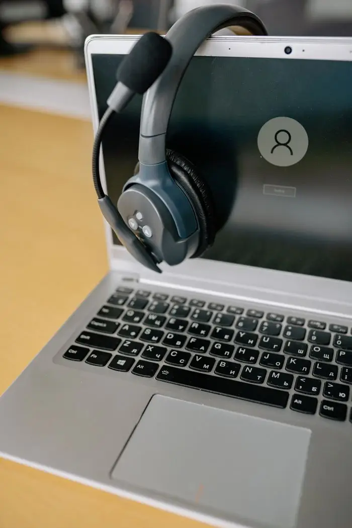 Nos Services Close-up of a laptop with a headset, symbolizing online communication and remote work.